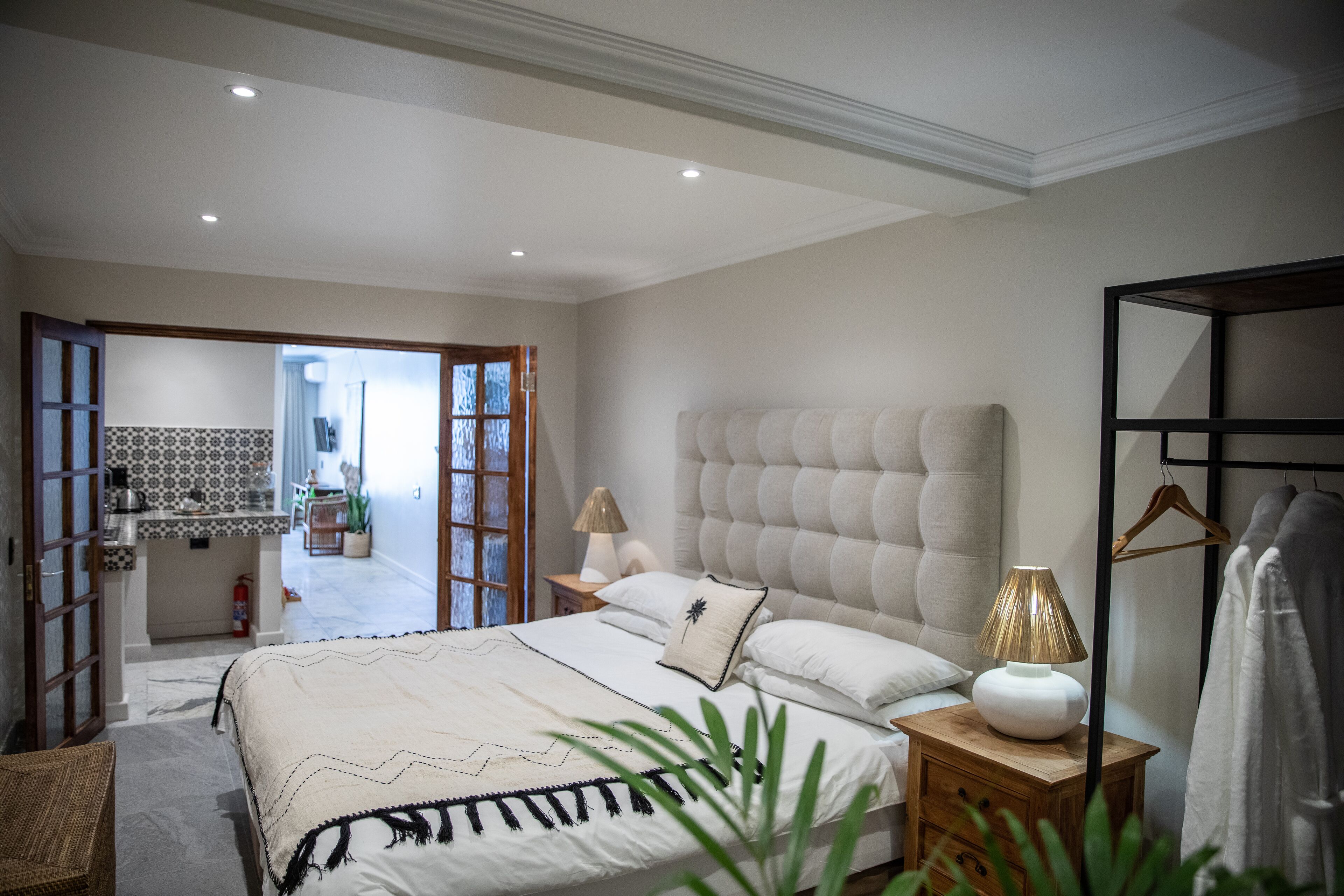 Una camera da letto con un letto grande, comodini, un armadio a parete e vista sul bagno.