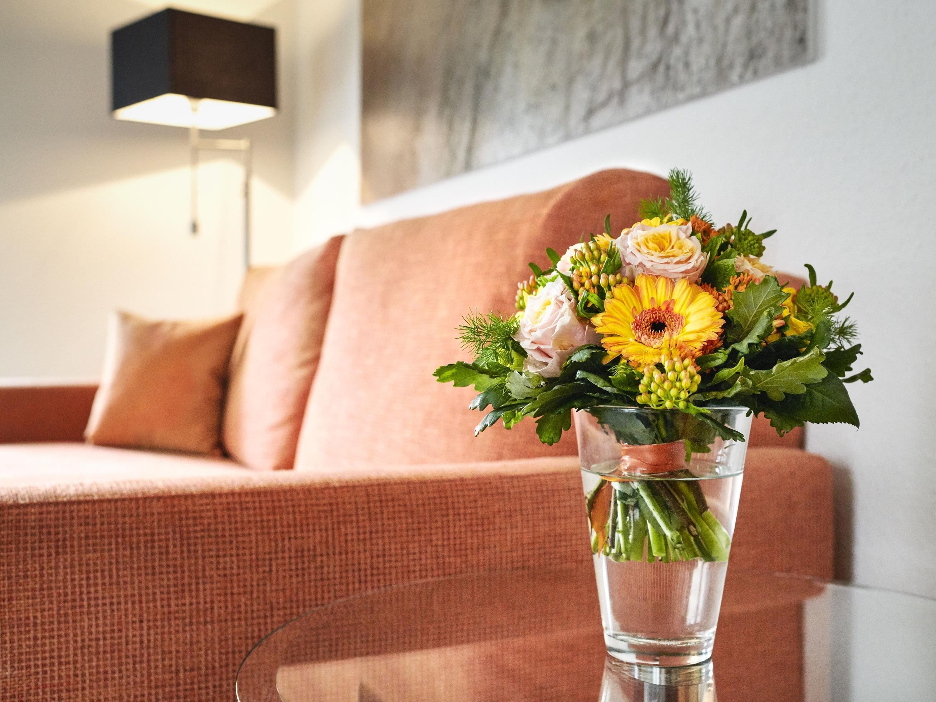 Eine transparente Glasvase mit einem Blumenstrauß auf einem Tisch.