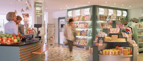 Un hall d’hôtel comprenant un comptoir d’accueil, un présentoir à magazines et un sol carrelé.