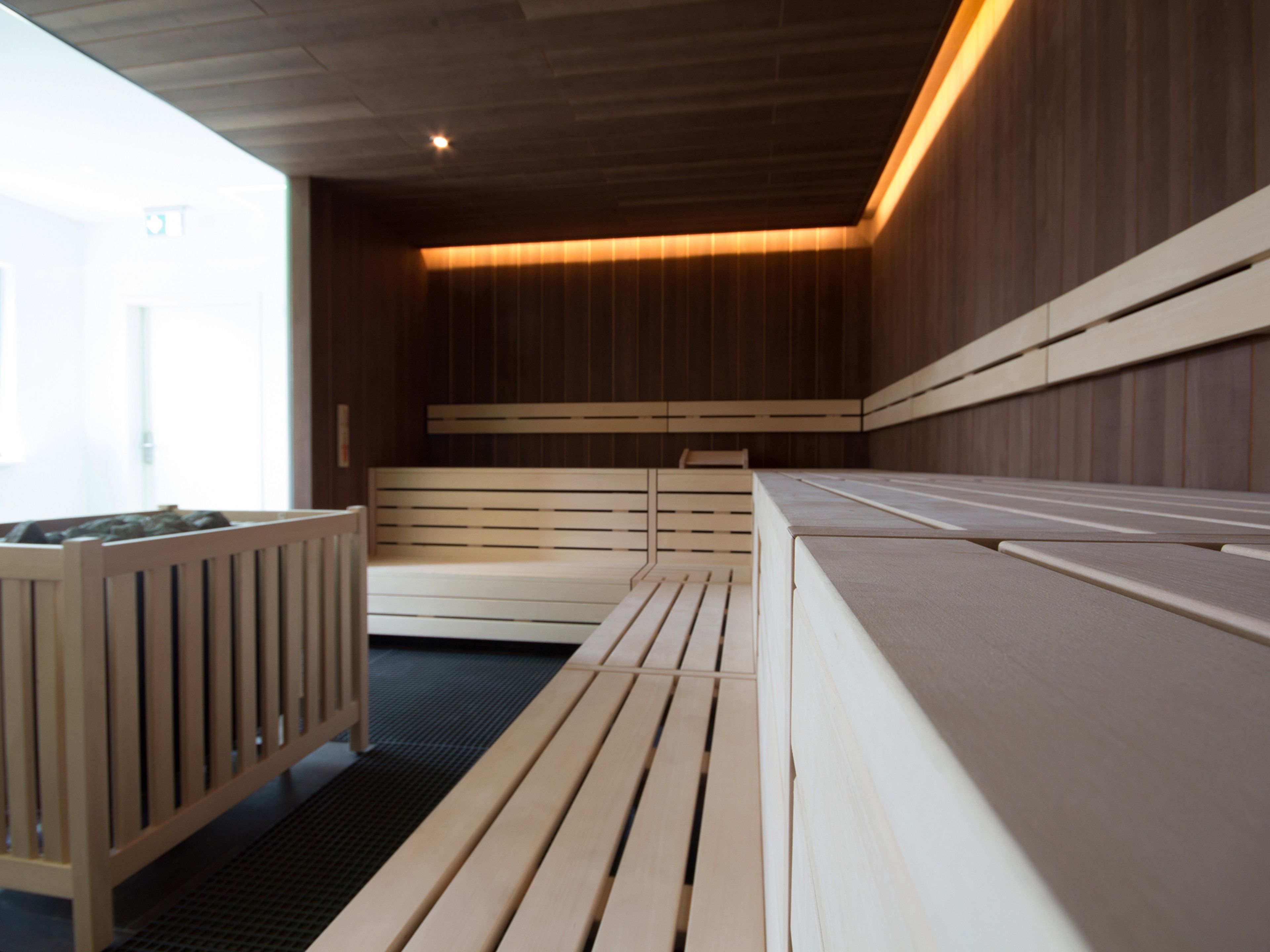 Una moderna sala spa con panche in legno e un piccolo angolo relax.