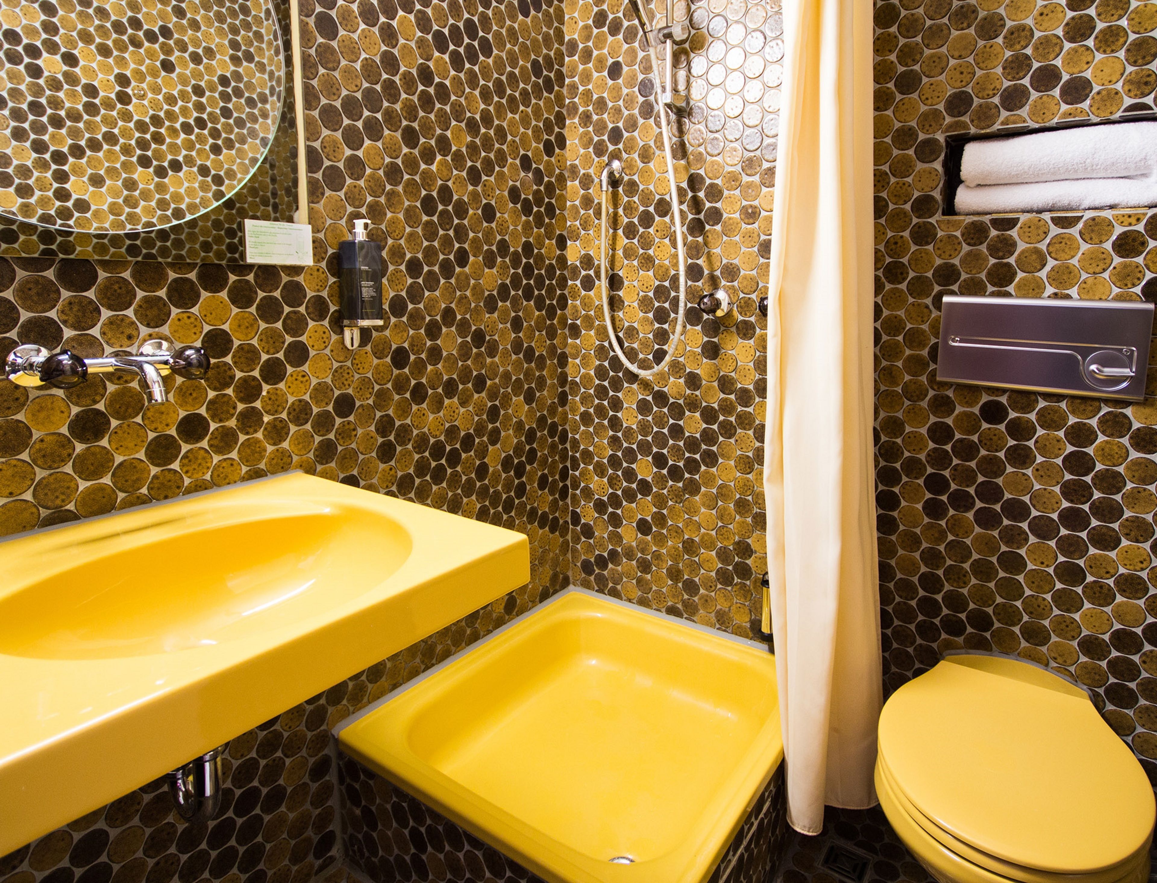 A bathroom with a yellow sink, a yellow bathtub, and a toilet.