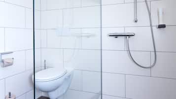 Une salle de bain moderne avec une douche à parois de verre, des toilettes blanches et un pommeau de douche à main.