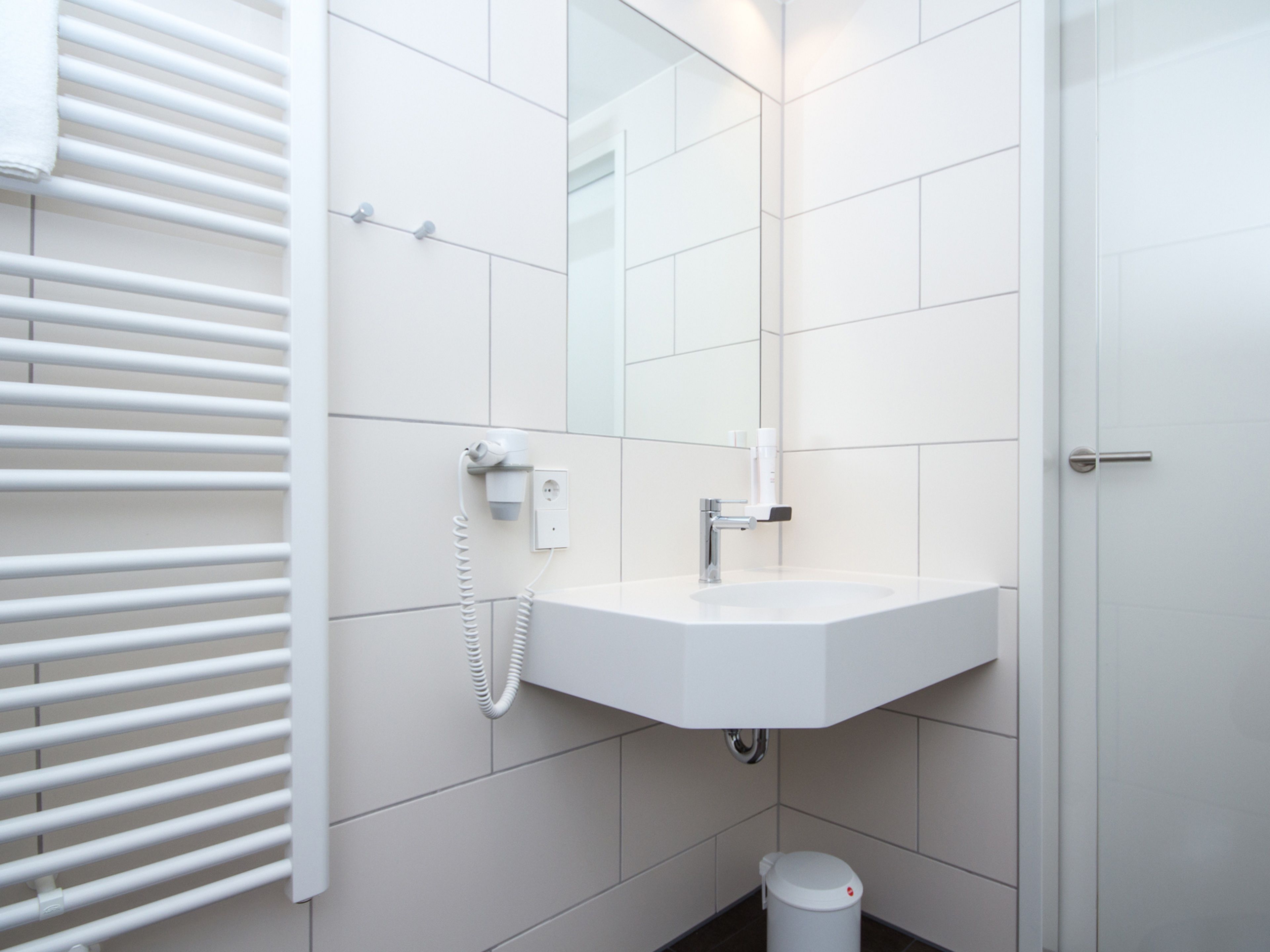 Ein modernes Badezimmer mit Waschbecken, Spiegel und Handtuchhalter.