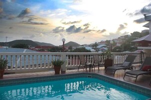 Una piscina al aire libre, tumbonas