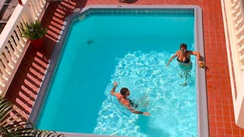 A rectangular swimming pool with two people swimming.