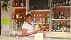 A bar area with shelves stocked with various liquor bottles. - Bunker Hill Hotel (St. Thomas)