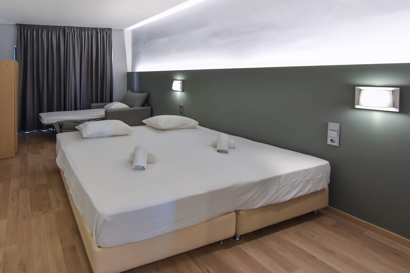 Una habitación de hotel con una cama grande, mesitas de noche, un escritorio y una silla.