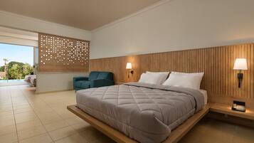 A modern bedroom with a large bed, a seating area, and a view of the outdoors.