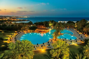 A resort with a large swimming pool, sun loungers, and a view of the sea. - Kresten Palace Hotel (Rhodes)