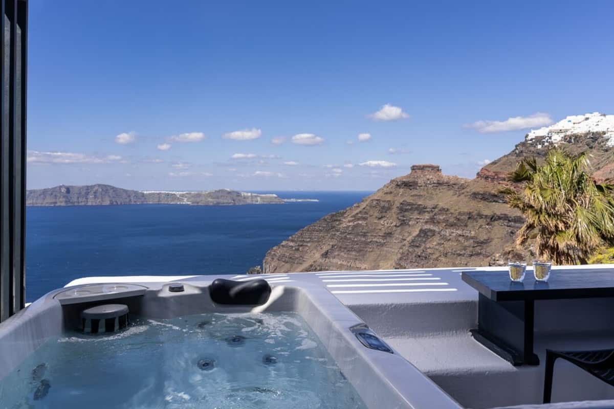 Uma banheira de hidromassagem com vista desimpedida para o oceano e falésias.