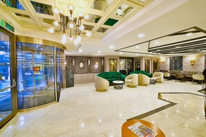 A hotel lobby with a green sofa, multiple chairs, a reception desk, and a glass entrance. - Four Sides Taksim Lion Hotel&Spa (Istanbul)