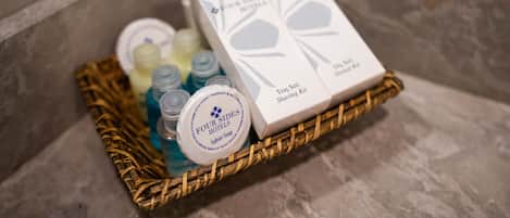 Una cesta de mimbre con un kit de afeitado y botellas de jabón de Four Sides Hotels.