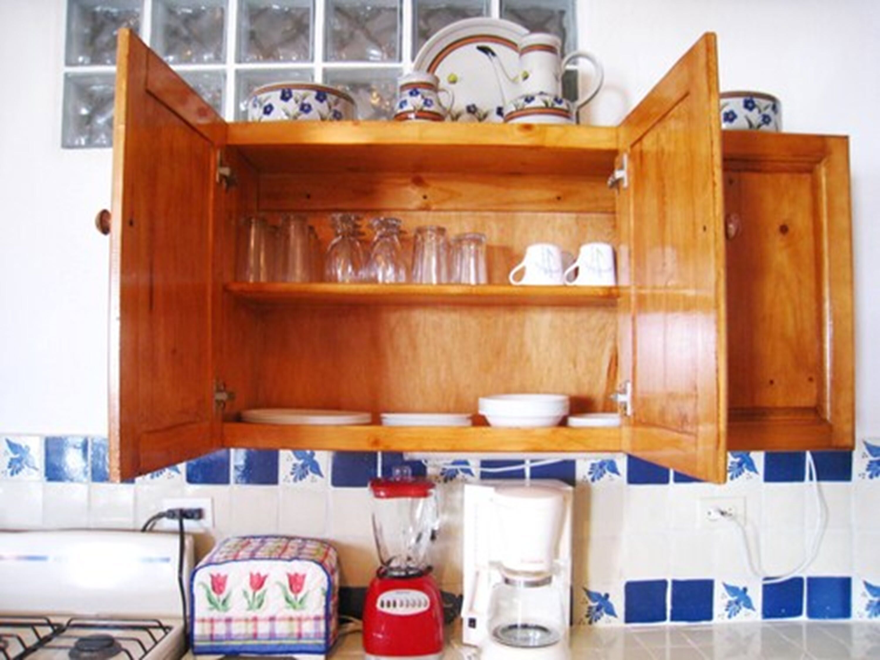 Una cucina con un armadietto in legno, un tostapane, un frullatore e una macchina da caffè.