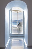 Un pasillo que lleva a un balcón con vistas al mar y a las montañas.