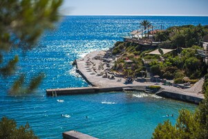 Una località balneare con vista libera sul mare, una spiaggia sabbiosa e un molo.