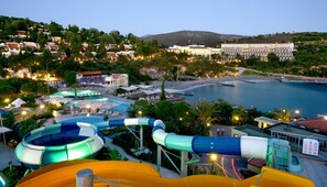 A water park with slides and pools, surrounded by buildings and a beach. - Pine Bay Holiday Resort (Kusadasi)
