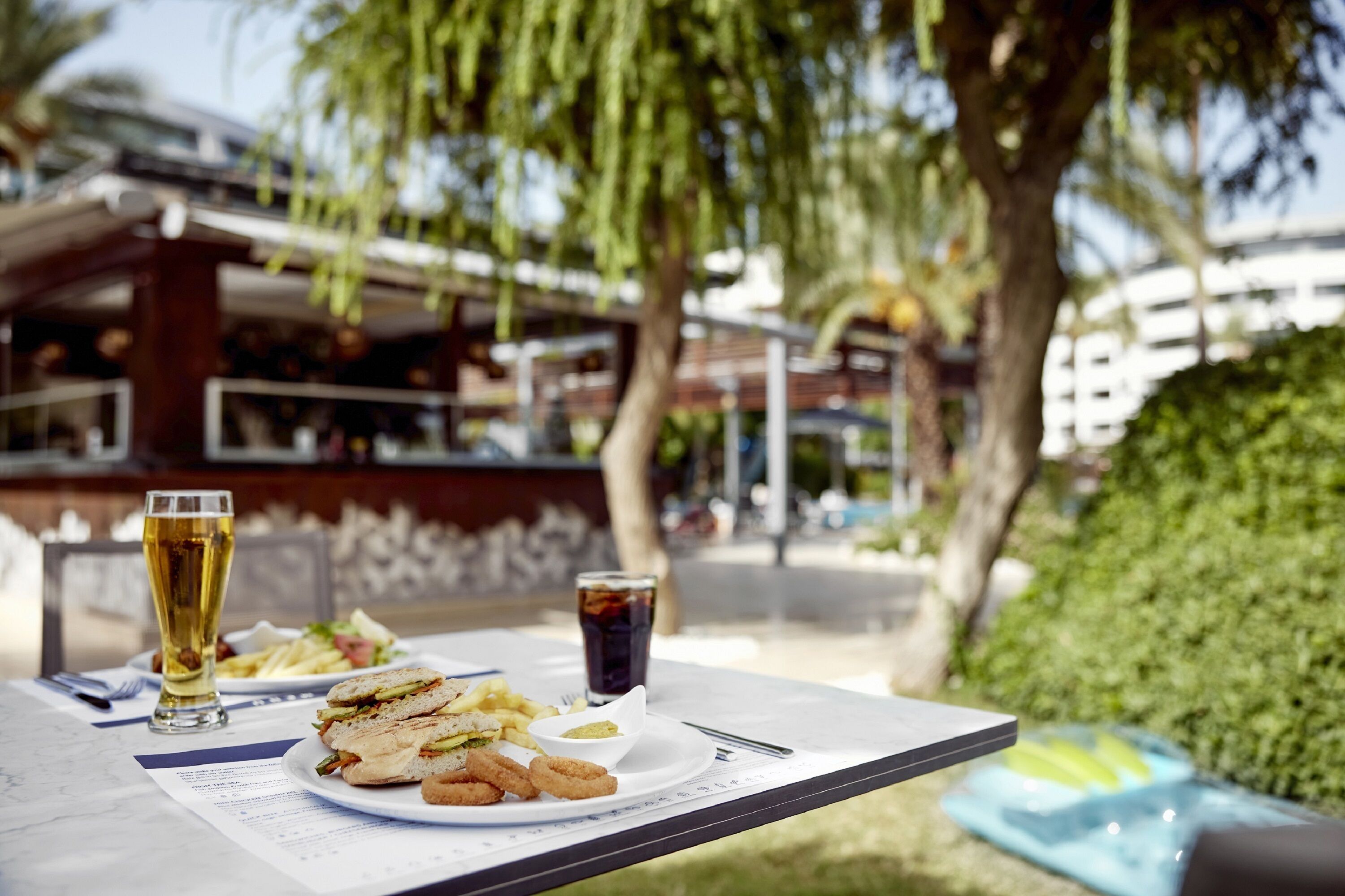 Une table avec un repas, un verre de bière et une autre boisson.
