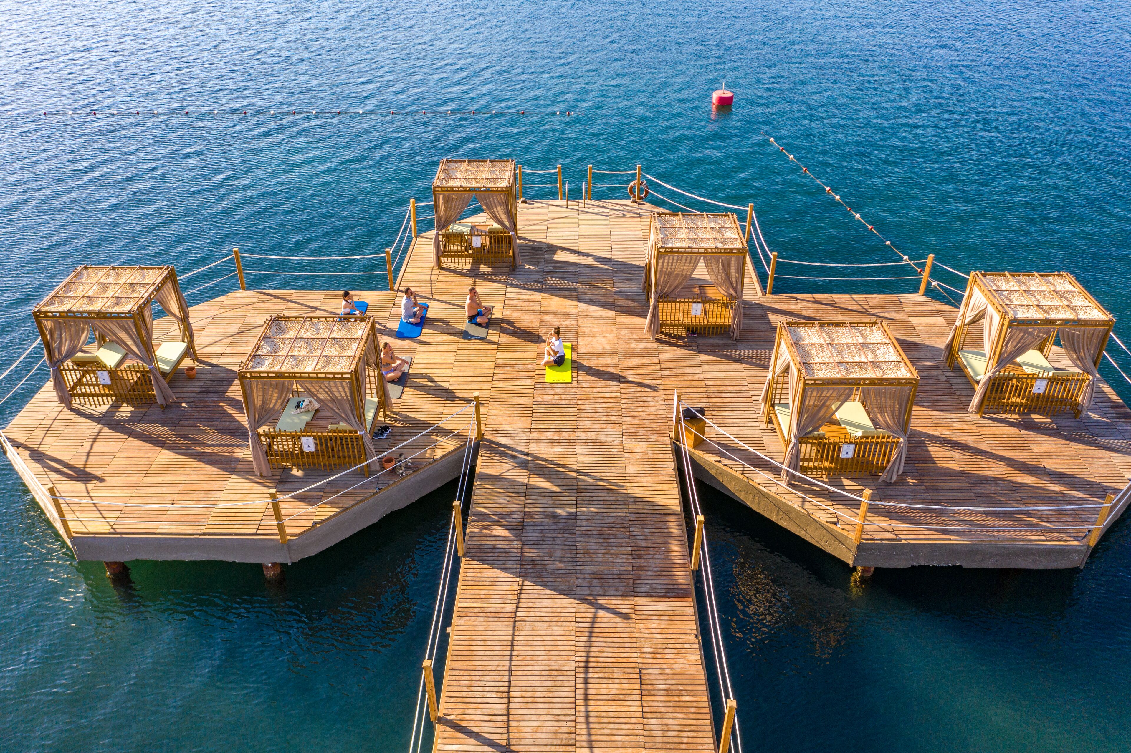A wooden deck with four enclosed seating areas and a central open space.