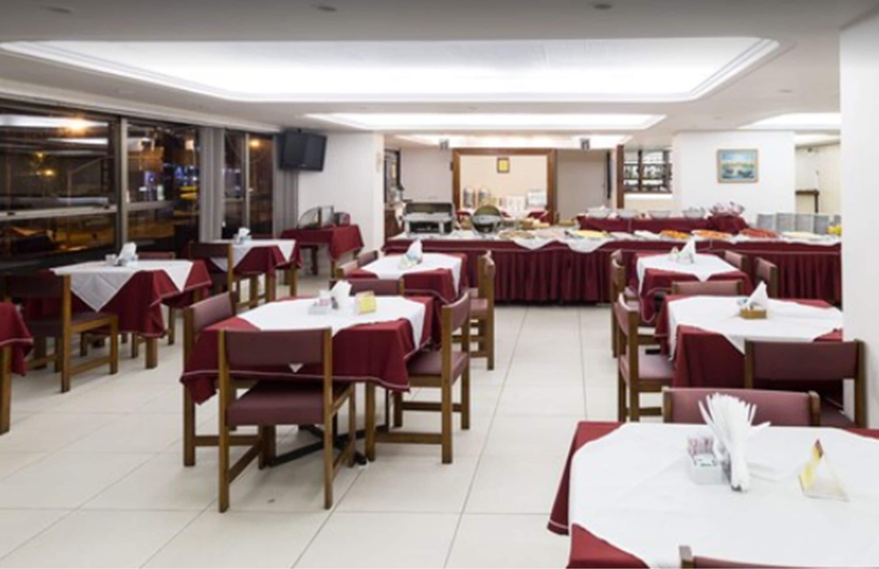 A dining area with multiple tables and chairs, arranged in rows.