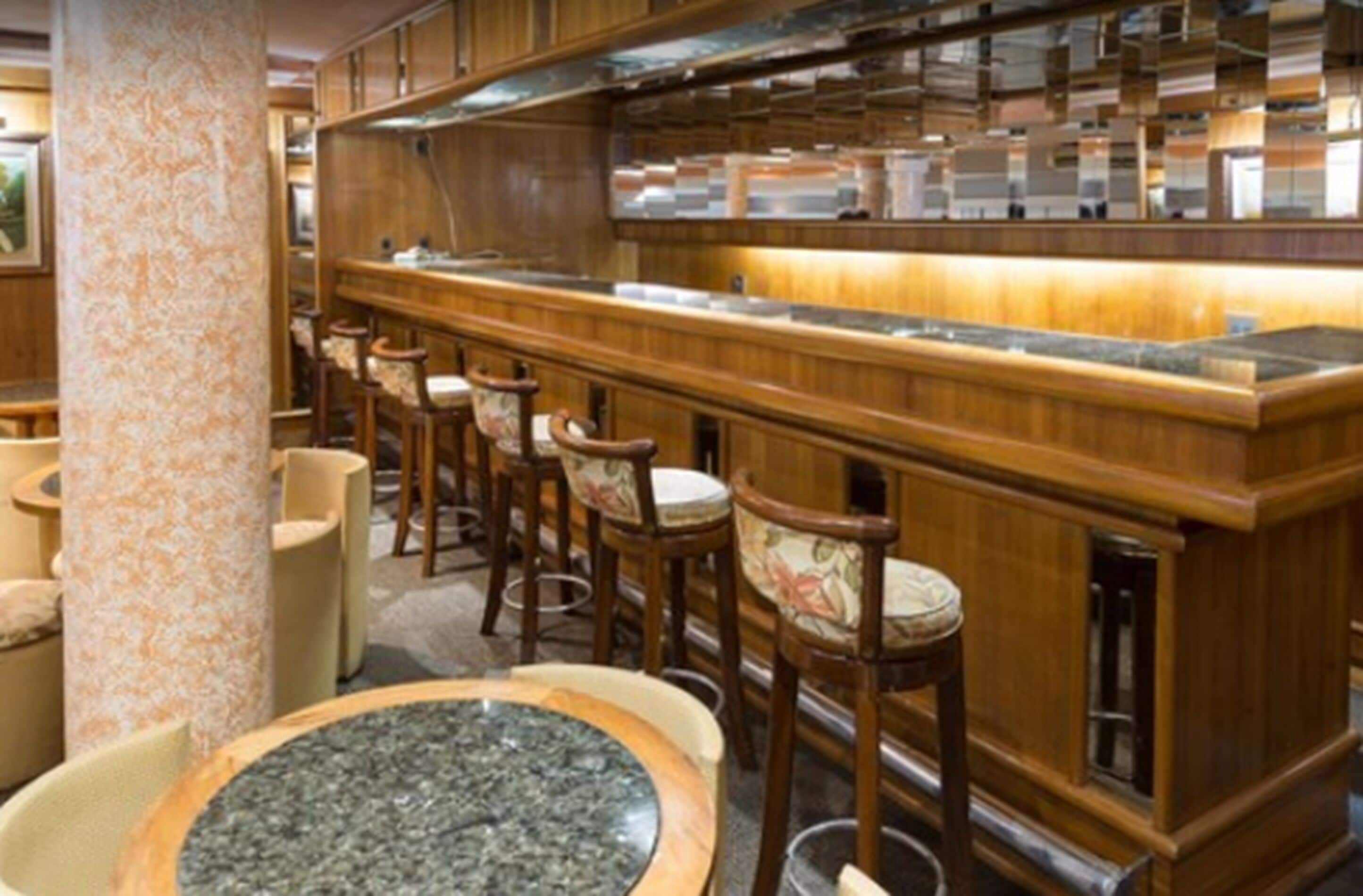 A bar area with wooden furniture and a marble countertop.