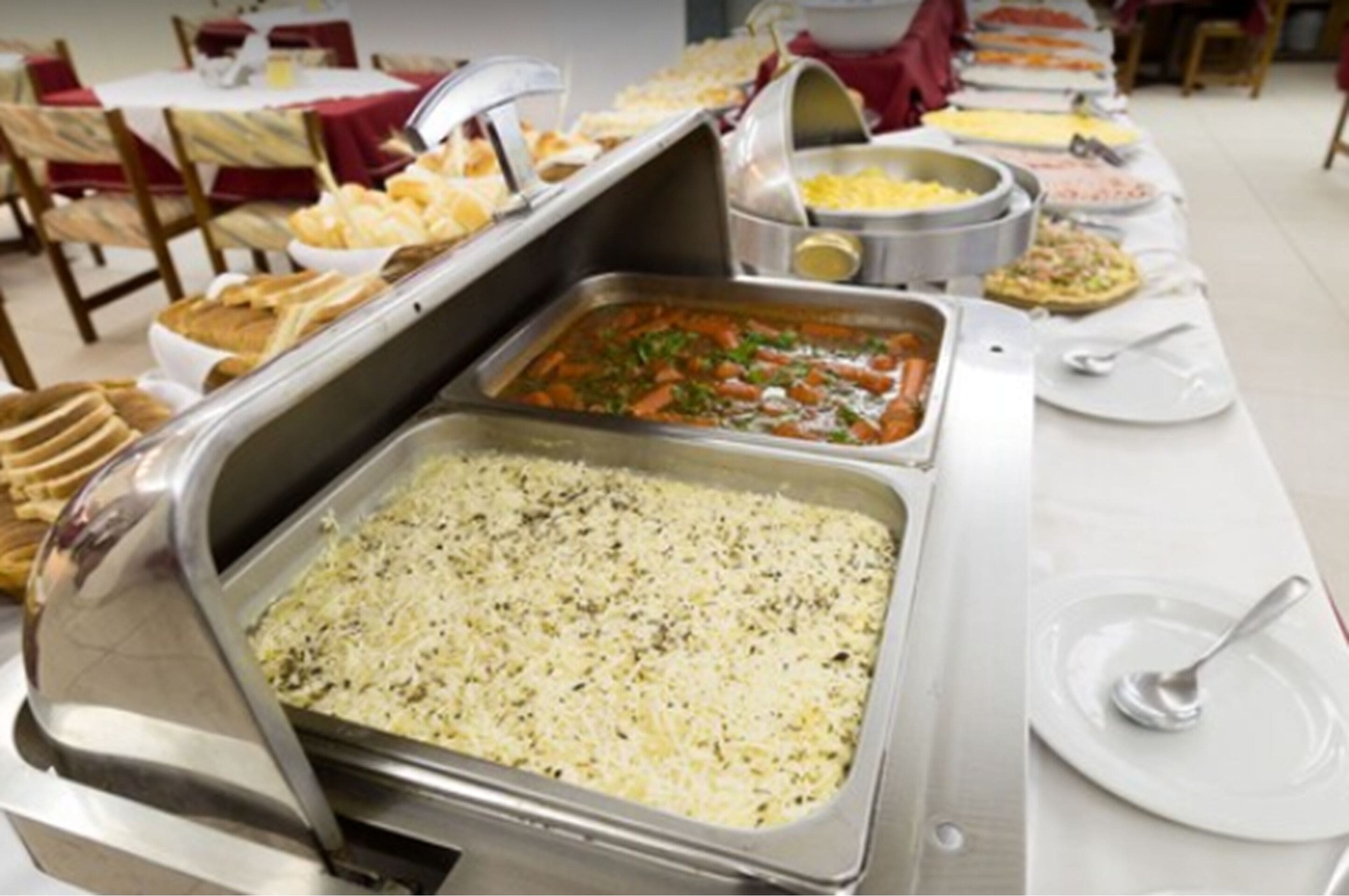 Une table de buffet proposant divers plats, notamment des pâtes, des salades et du pain.