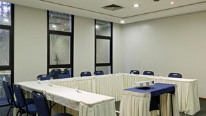 A conference room with a long table, chairs, and a projector.