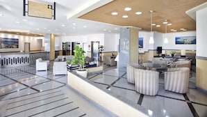 A spacious lobby with a reception desk, seating area, and a large plant. - Bahiamar Hotel (Salvador)