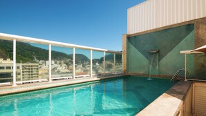 A rooftop swimming pool with a clear view of a cityscape and mountains in the background. - Hotel Bandeirantes (Rio de Janeiro)