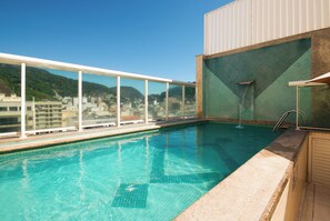 Een buitenzwembad, parasols voor strand/zwembad