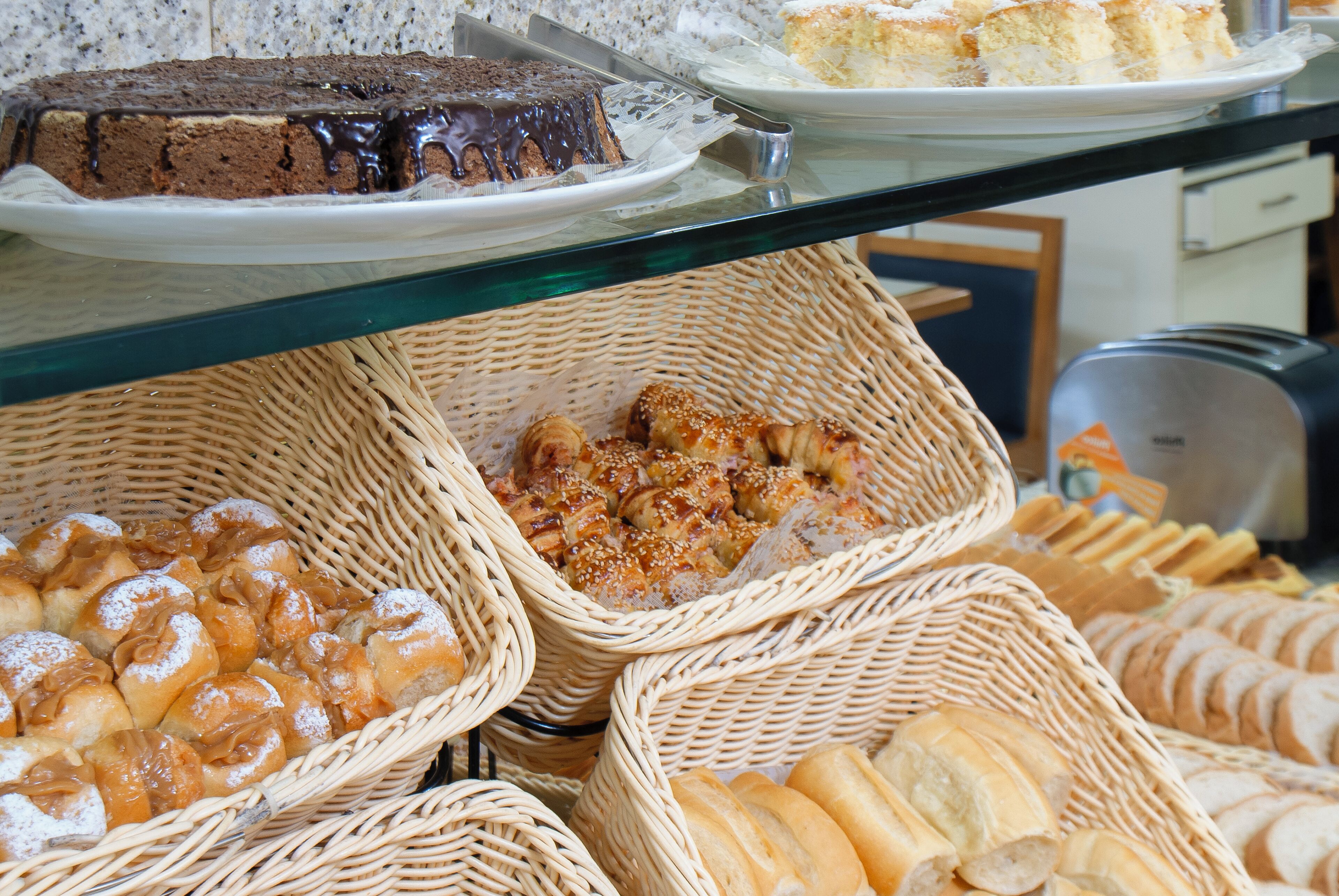 A buffet with various baked goods including cakes, pastries, and bread.