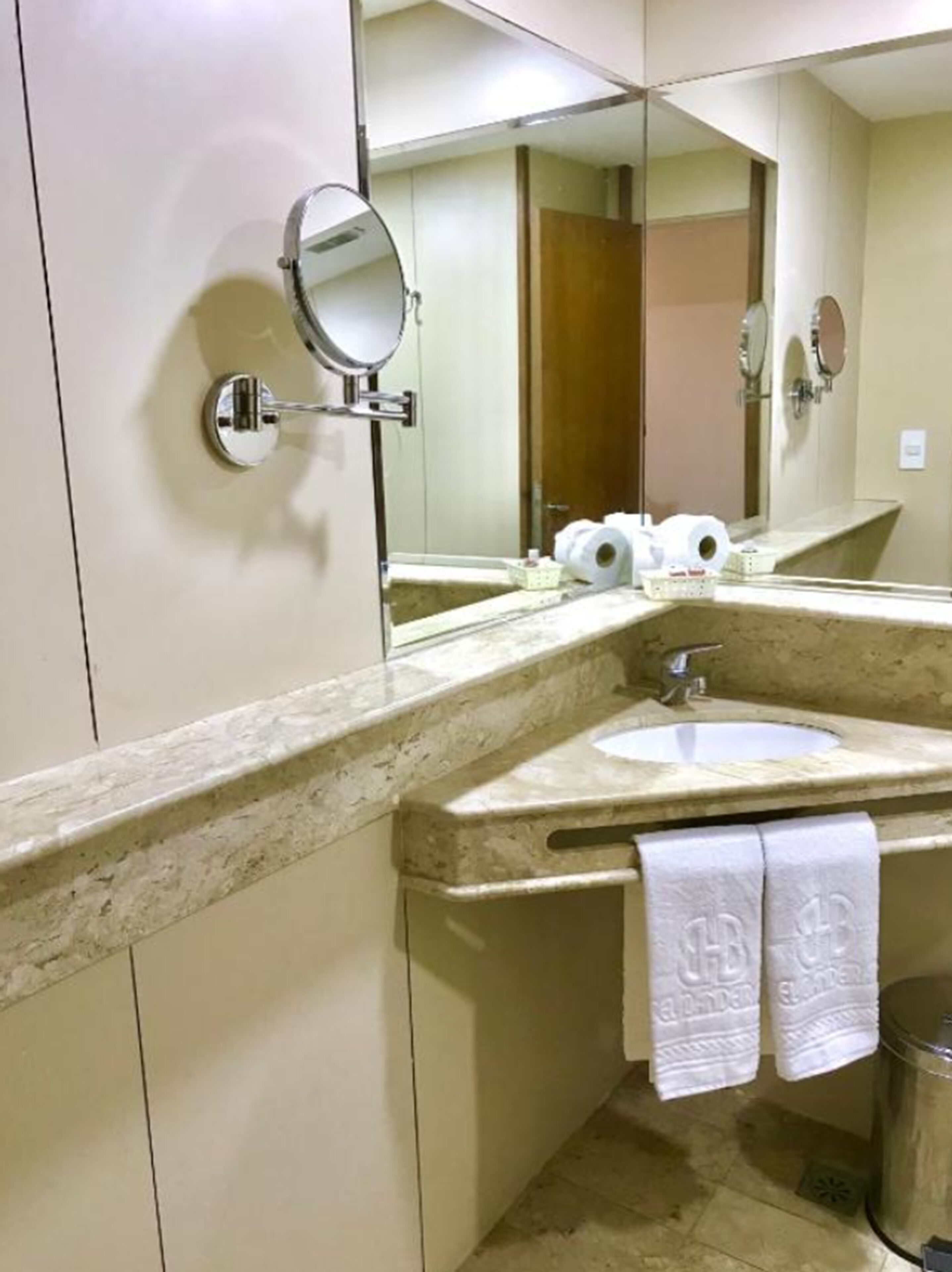A bathroom with a sink, mirror, and towel rack.