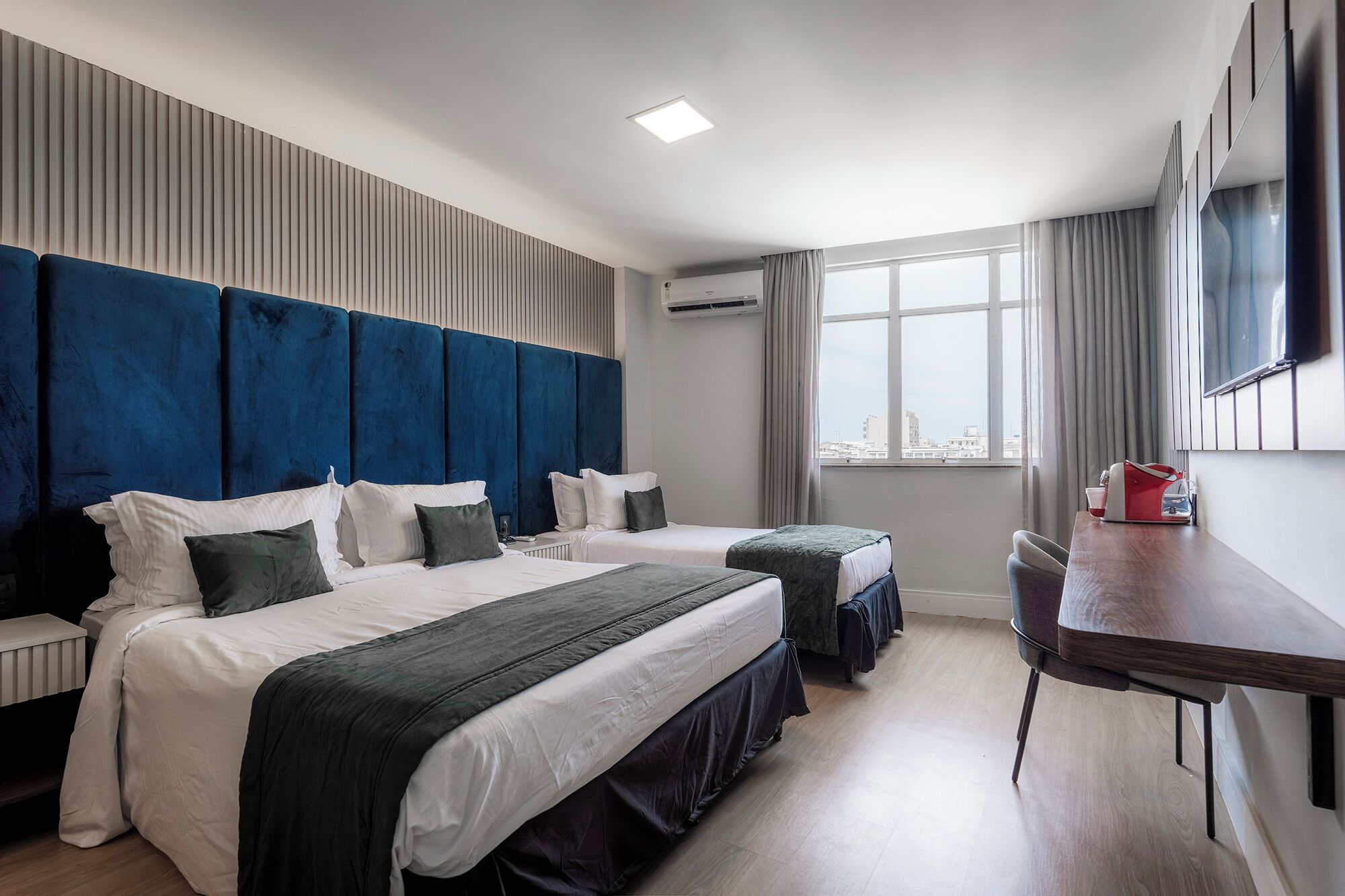 Deluxe Triple Room | Minibar, in-room safe, desk, laptop workspace