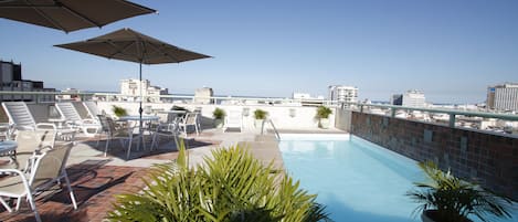 Una piscina al aire libre, sombrillas