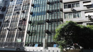 Un moderno edificio de hotel con fachada de vidrio y varias unidades de aire acondicionado.