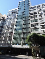 Un moderno edificio de hotel con fachada de vidrio y varias unidades de aire acondicionado.