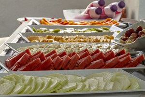 Un bufé con diversos alimentos, incluyendo sandía, melón y otras frutas.