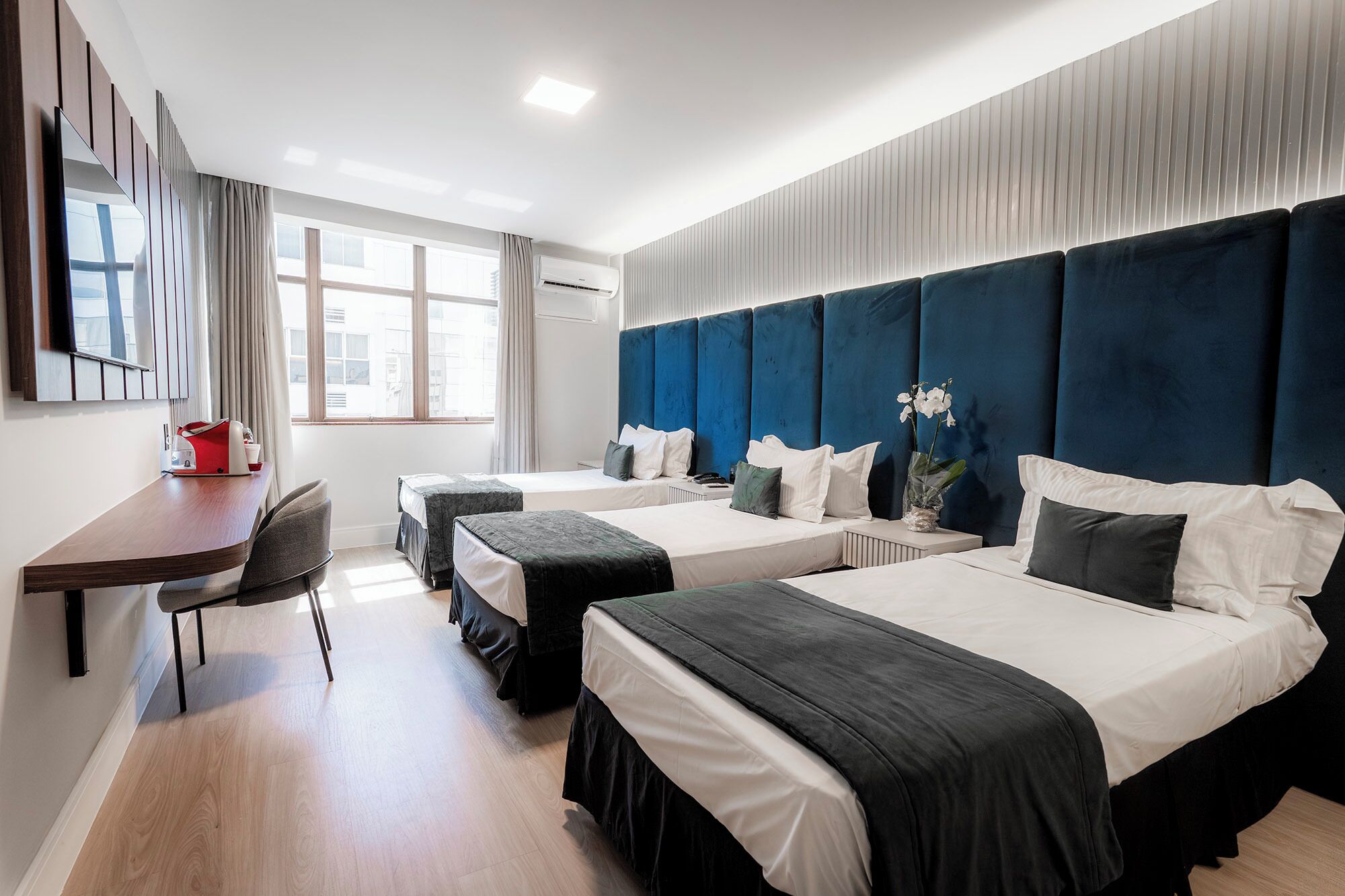 Deluxe Triple Room | Minibar, in-room safe, desk, laptop workspace