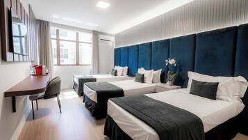 Deluxe Triple Room | Minibar, in-room safe, desk, laptop workspace