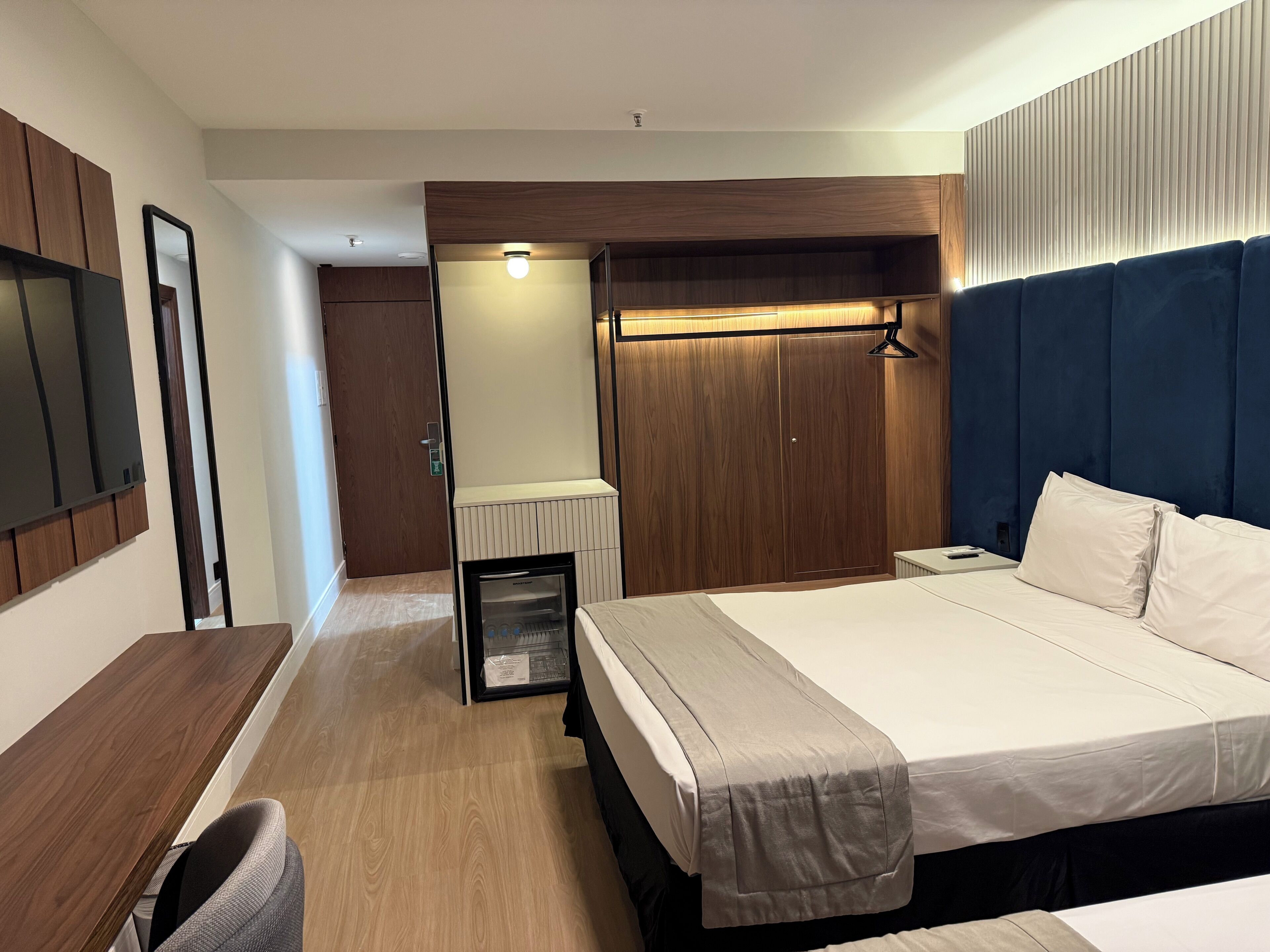 Una habitación de hotel con cama, mesita de noche y armario.