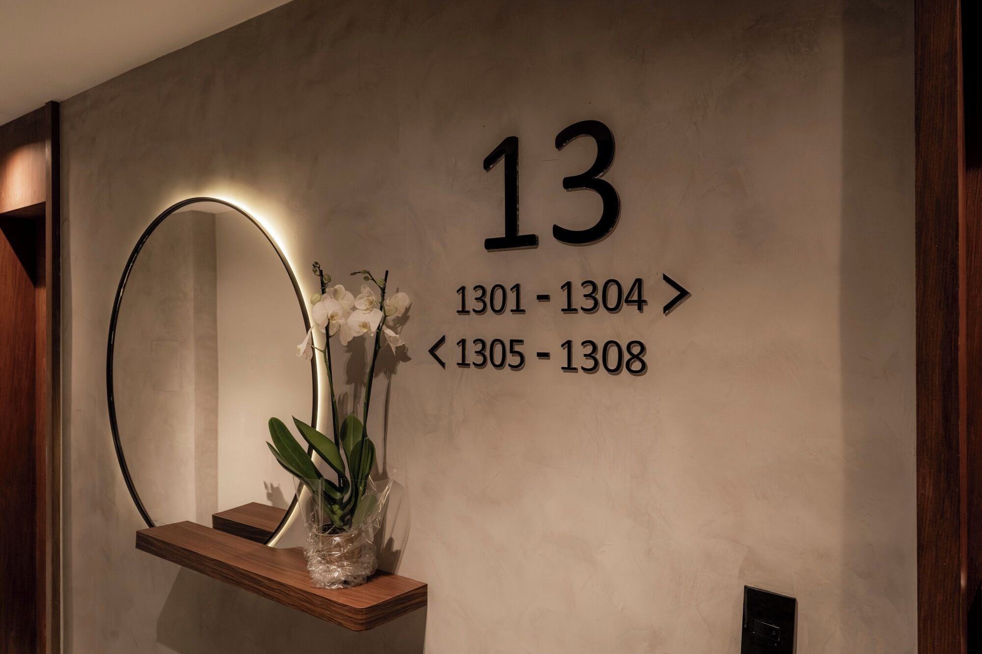 Un mur sur lequel figure le chiffre « 13 » ainsi que les numéros de chambre « 1301-1304 » et « 1305-1308 », indiquant les numéros des chambres d’hôtel.