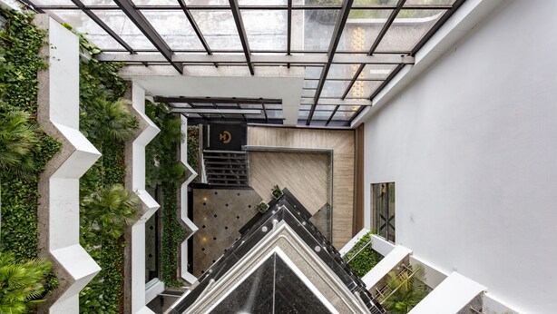 A modern interior with a geometric design, a staircase, and a view through a glass ceiling. - Cambirela Hotel (Florianópolis)