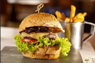 A burger with fries on a metal tray.
