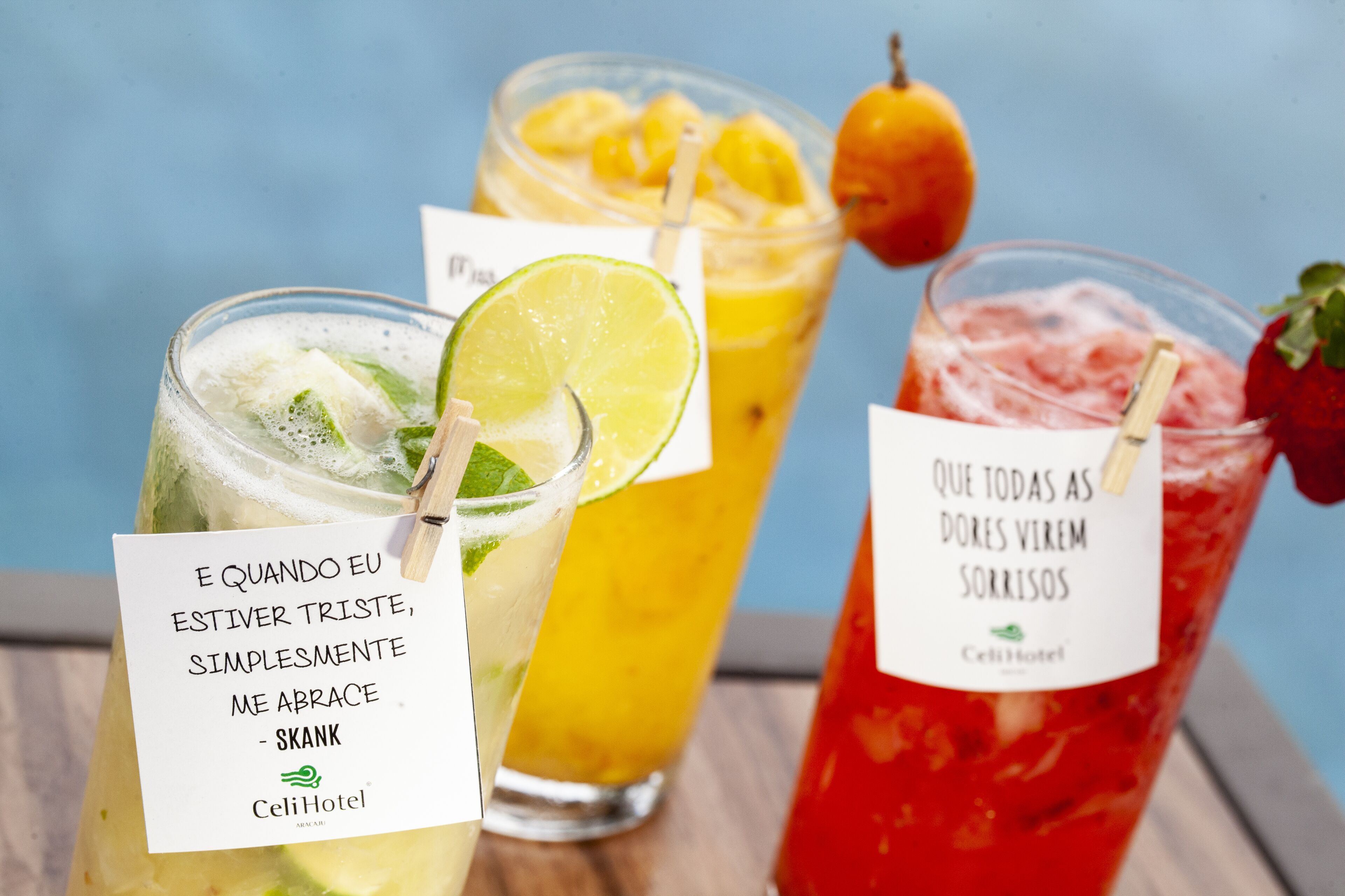 Three cocktails with lime and mint garnishes, and a quote card on the first drink.