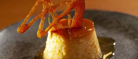 Un postre en un plato con una capa caramelizada y detalles decorativos.