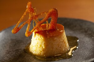 Sobremesa em um prato com cobertura caramelizada e detalhes decorativos.