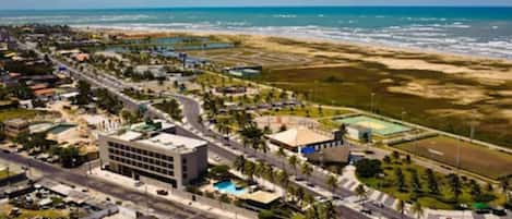 Vista aérea de un pueblo costero con playa, carreteras y edificios.