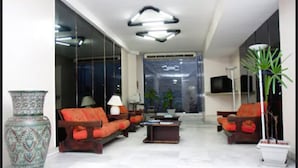 Una sala de estar moderna con un conjunto de sofás, una mesa de centro y un gran jarrón decorativo.