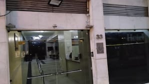 Entrada de un hotel con puerta de cristal, una escalera que conduce al interior y un letrero con el nombre del hotel.