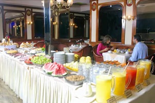Un buffet con frutta, verdura e bevande assortite.