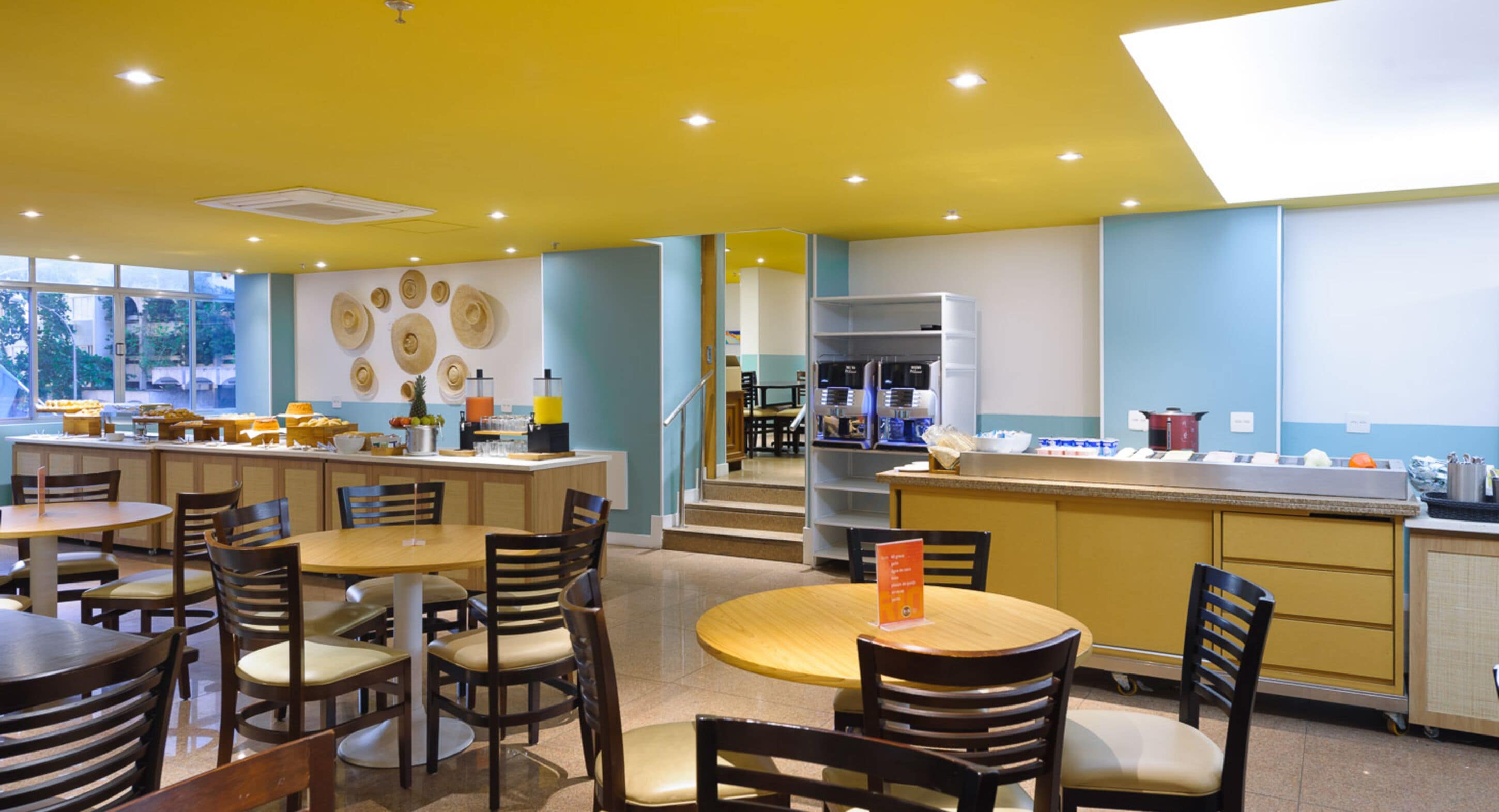 A restaurant with a central island, multiple seating areas, and a kitchen in the background.